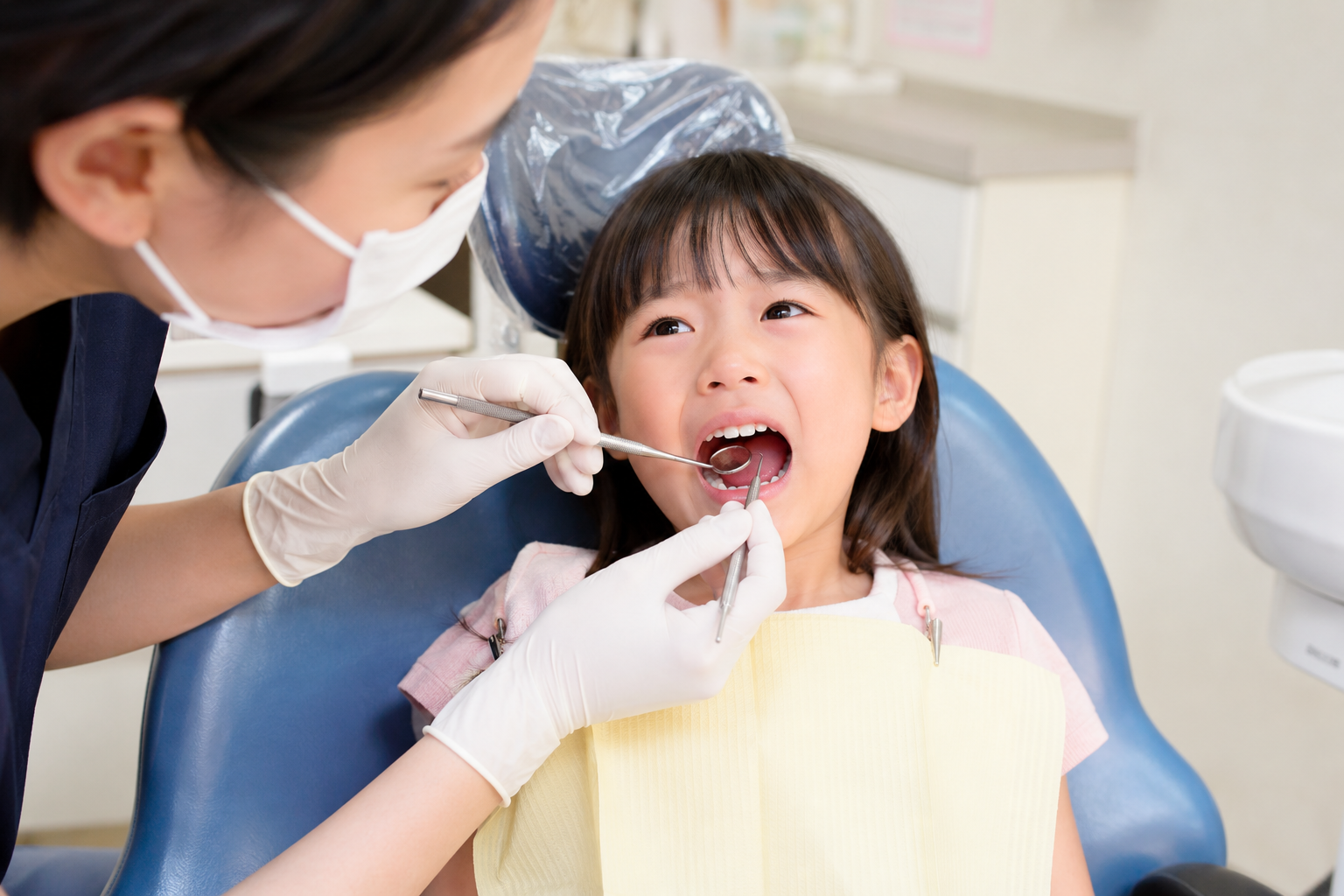 歯をぶつけた子どもの口の中を落ち着いて確認する保護者