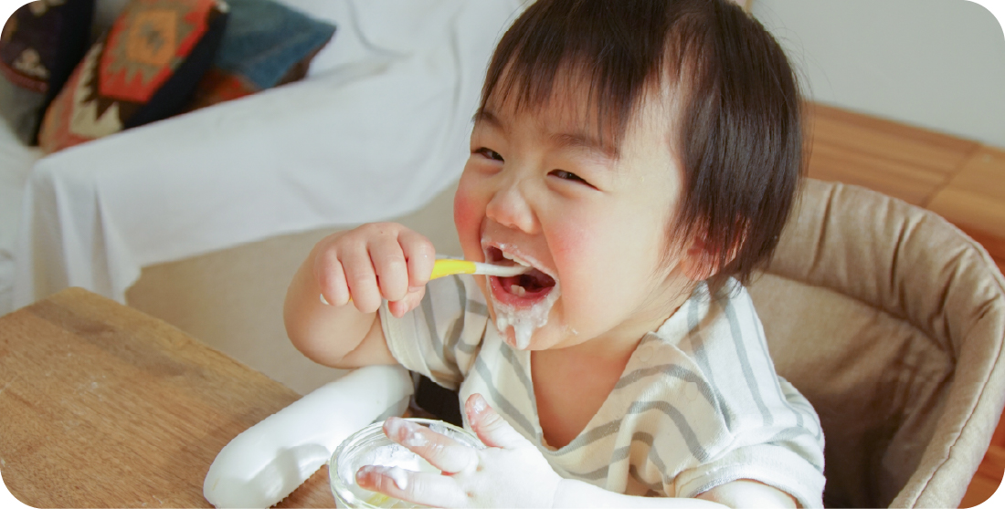 フォークでごはんを食べる赤ちゃん